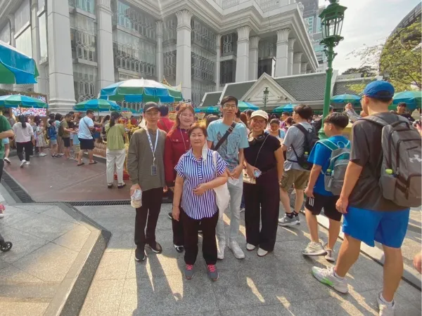 A group of people in a big square smilling at camera