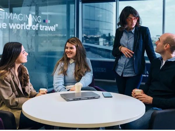 A group of people gathered in an office talking to each other relaxed