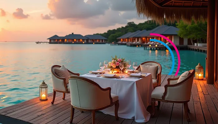 A dinner table on a wooden harbour, with the sunset and a beach as background