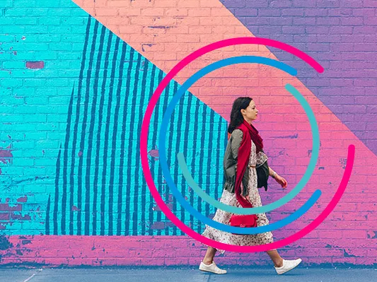 A woman walking along a brightly coloured wall, representing a creative travel hub. Used as a web header for HBX Group's Travel Trend Report 2026.