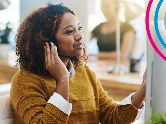 A woman in a call centre environment working on a computer